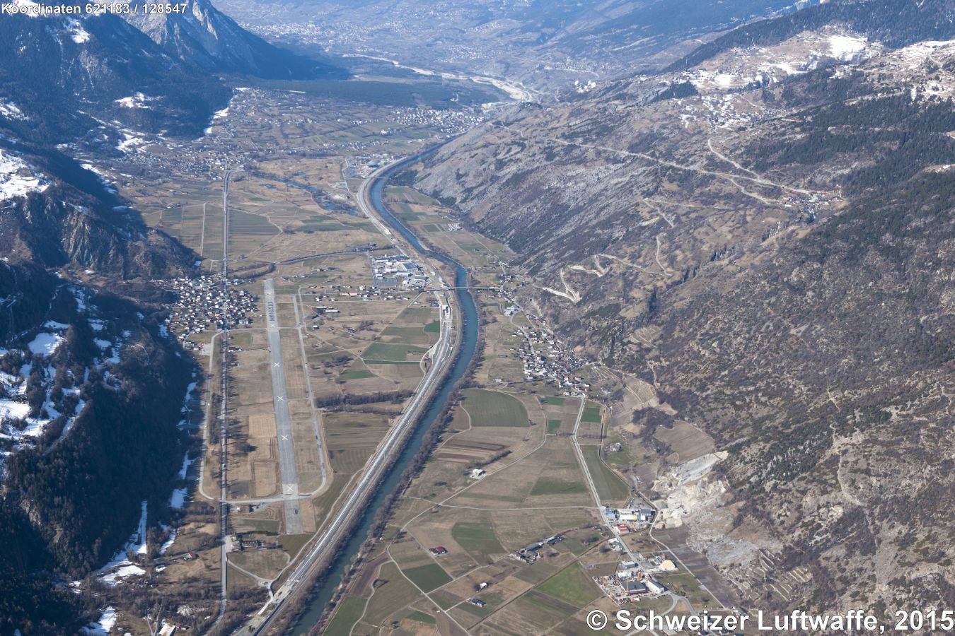 Dorf Bildmitte links: Turtmann mit ehemaligem Flugplatz. Bildmitte rechts der Rhone: Niedergampel und Rhonebrücke zum Industrieareal. Position: 2'621'166.25, 1'128'675.07 - Strassenkehren nordwärts nach Bratsch und von dort südwärts nach Erschmatt.- Hintergrund Bildmitte: Phynwald (Forêt de Finges), einer der grössten zusammenhängenden Föhrenwälder der Alpen und Naturpark, offener Rhonelauf.